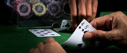 Eine Hand hält zwei Spielkarten.