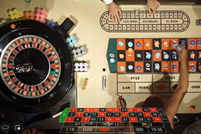 Auf dem Bild sieht man, wie Spielerinnen und Spieler ihre Einsätze im echten maltesichen Casino platzieren.