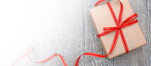 Ein Geschenkpaket und das Logo des Anbieters mit dem besten Big Time Gaming No Deposit Bonus.