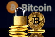 Bitcoin Münzen und ein Vorhängeschloß.