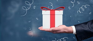 Eine Hand hält eine Box mit Schleife.