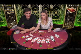 Zu sehen sind ein Dealer und ein Moderator, die die Mitspieler beim Blackjack Party von Evolution Gaming animieren.