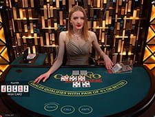 Zu sehen ist eine blonde junge Dealerin, die gerade den Flop bei einer Runde Casino Hold'em Poker gegeben hat.