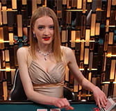 An einem Poker Tisch sitzt eine blonde Dealerin und gibt gerade den Flop.