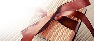 Vor dem Hintergrund eines ungeöffneten Geschenkpaketes ist das Logo des Online Casinos mit dem besten Pragmatic Play No Deposit Bonus zu erkennen.