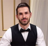 Das Bild zeigt einen bärtigen Dealer bei einer Runde Blackjack.